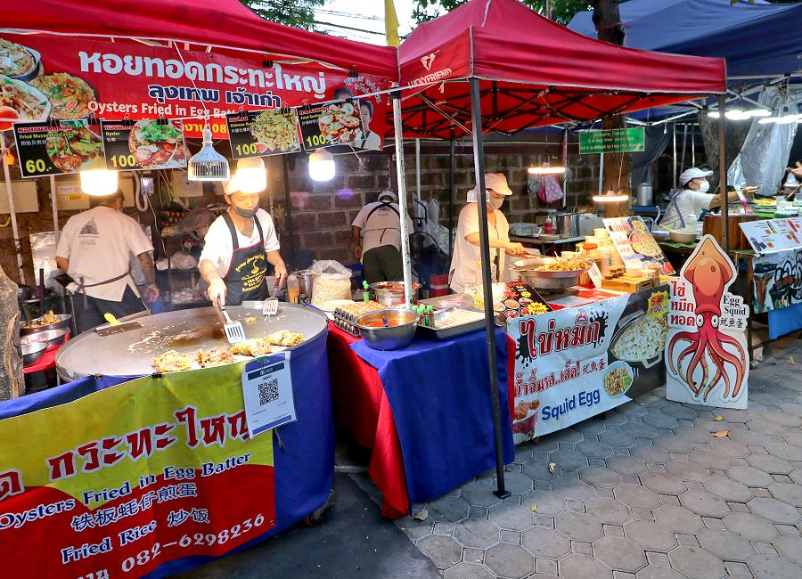 Essensstände am Sonntags-Nachtmarkt Chiang Mai mit Besuchern am Abend