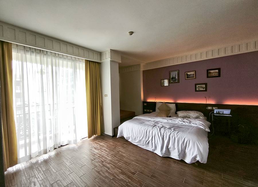 Blick vom Badbereich auf Bett und Balkon