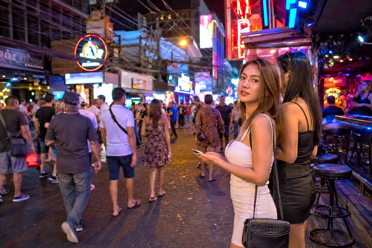 Nachtleben in Pattaya mit zwei Frauen und vielen Touristen in einer belebten Straße