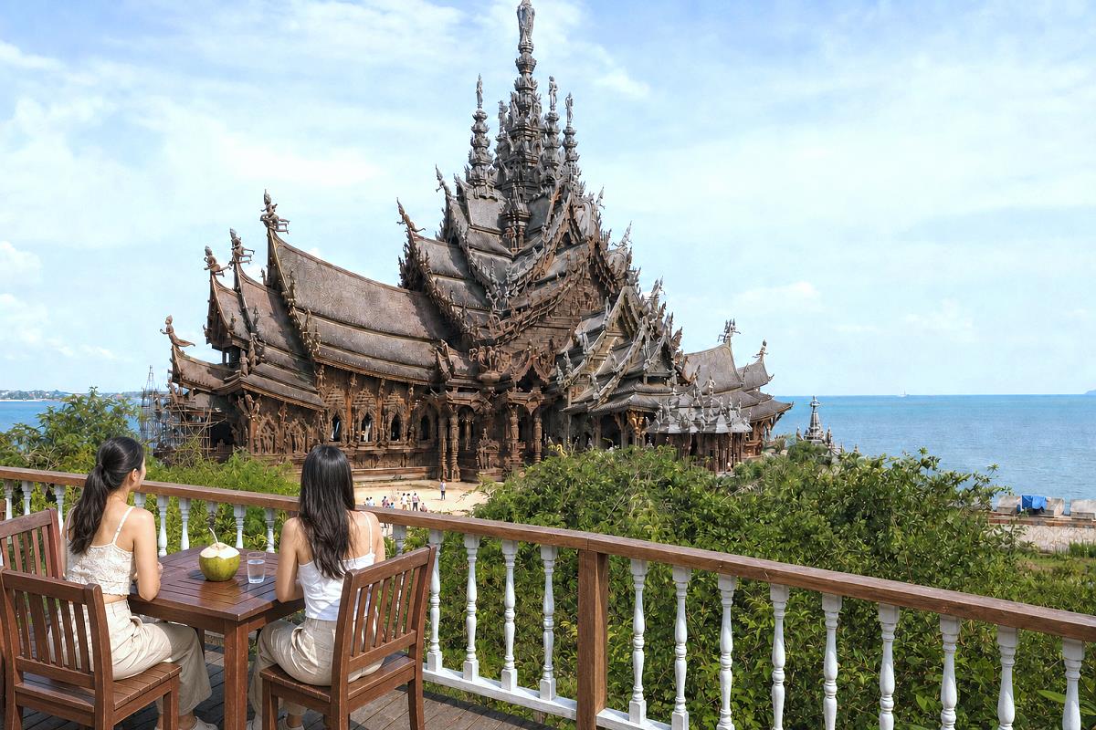 Zwei thailändische Frauen blicken von einer Terrasse auf das Sanctuary of Truth in Pattaya